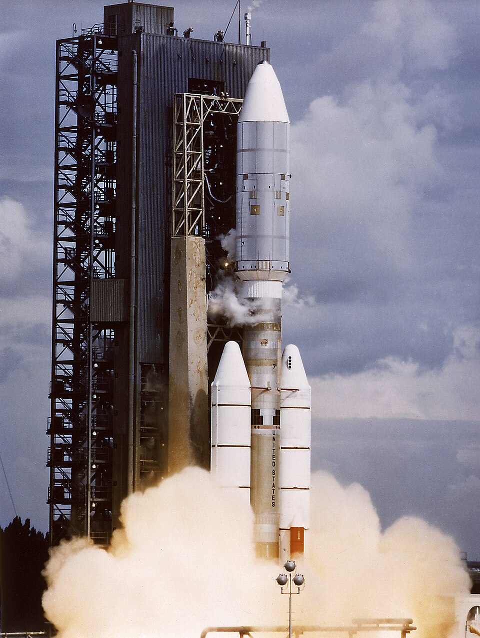 A Titan rocket lifting off from its launch tower in a cloud of smoke